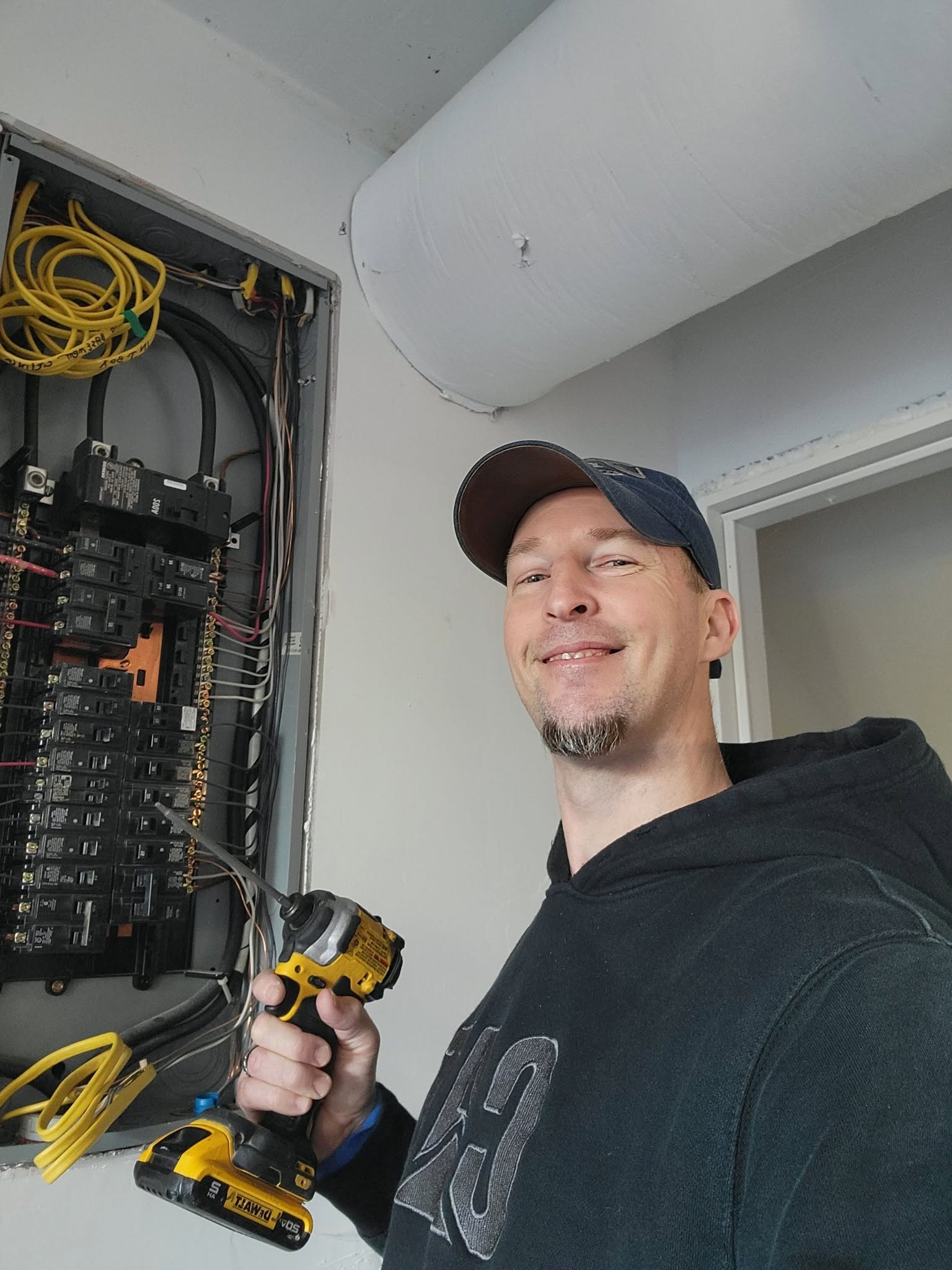 Licensed 253 Electric electrician standing in front of an electrical panel while troubleshooting wiring and diagnosing electrical problems in a Puyallup, WA home.