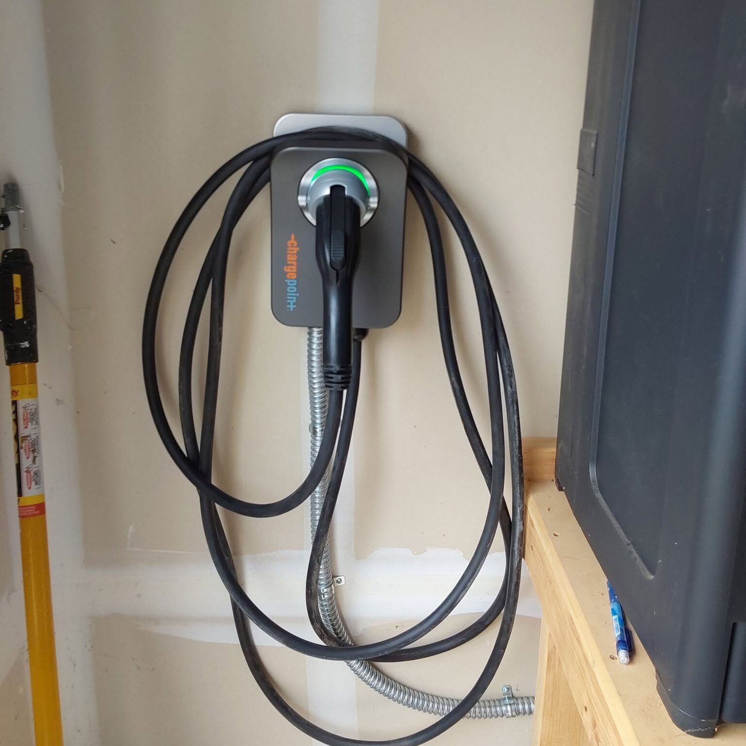 Licensed electrician installing a Level 2 EV charger in a residential garage.