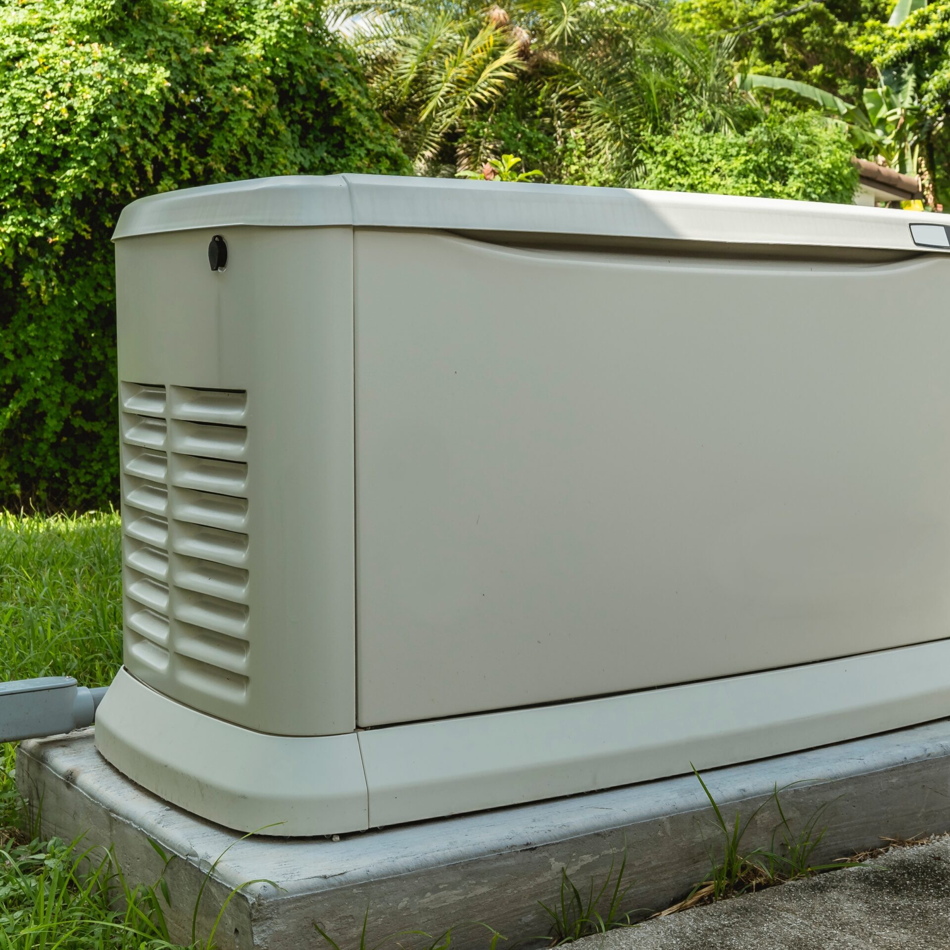 Licensed electrician installing a whole-home standby generator beside a residential home.